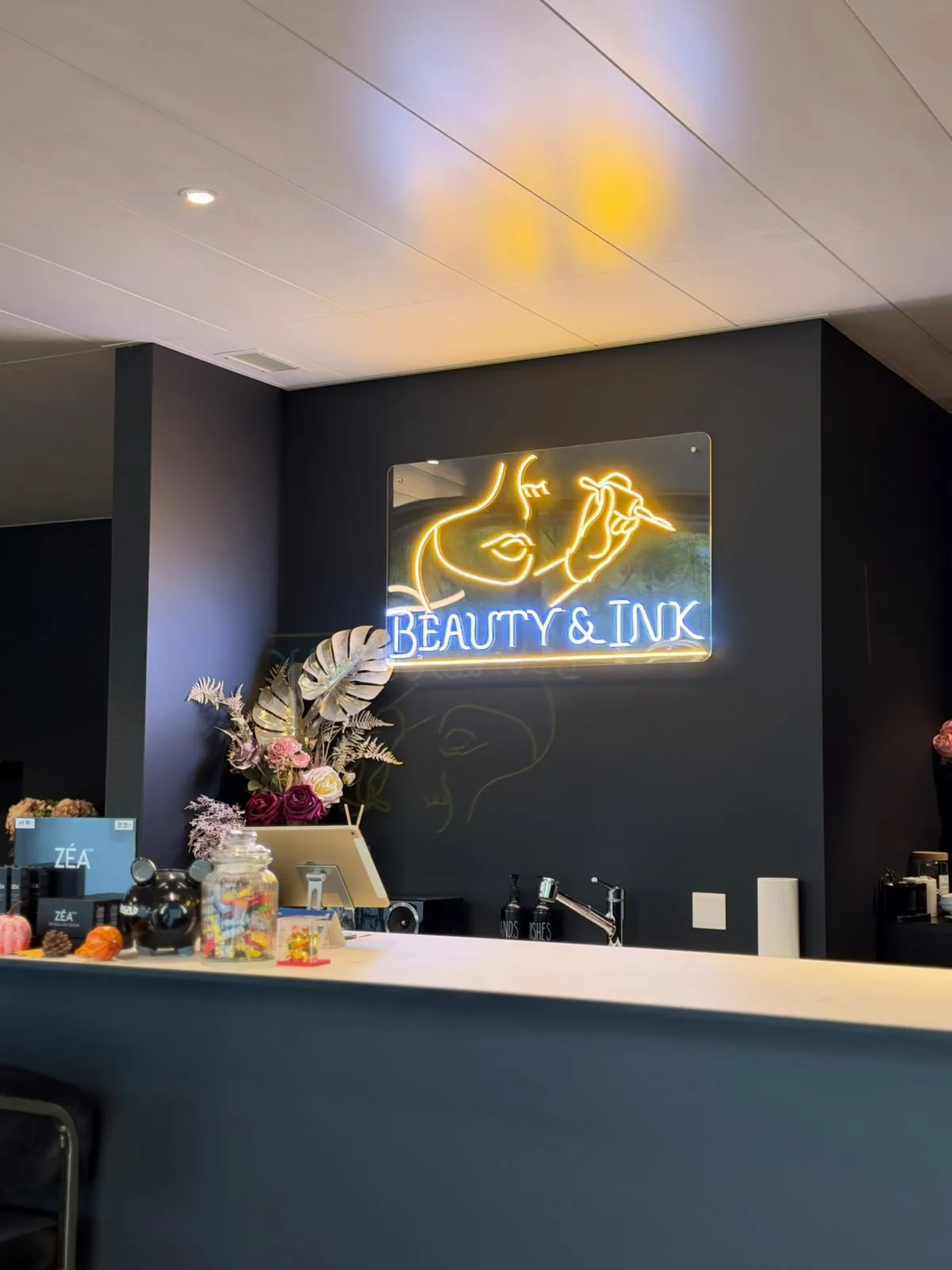 Empfang im Studio Beauty & Ink mit leuchtendem Logo